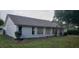 Rear view of a single story house with windows, and a yard at 4714 Cavendish Dr, New Port Richey, FL 34655