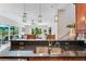 Kitchen boasts a center island with double sink, modern pendant lighting, and views to Gathering room at 11519 Belle Haven Dr, New Port Richey, FL 34654