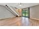Living area with wood-look floors, sliding door to patio, and staircase at 103 Brigadoon Dr, Clearwater, FL 33759