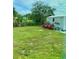 Large grassy backyard with storage shed and flowering bushes at 6196 Coralberry Ter, Port Charlotte, FL 33981