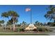 Gardens of Gulf Cove entrance with flag and landscaping at 6196 Coralberry Ter, Port Charlotte, FL 33981