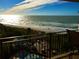 Stunning balcony view overlooking the ocean, beach, pool, and outdoor seating area at 2618 Gulf Blvd # 505, Indian Rocks Beach, FL 33785