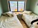 Bright bedroom featuring two twin beds, soft lighting, and a picturesque window view at 2618 Gulf Blvd # 505, Indian Rocks Beach, FL 33785