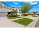 Two-story townhome with gray siding, two-car garage, and landscaped front yard at 7203 Sweet Alyssum Ct, Tampa, FL 33619
