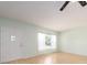 Empty living room with light walls and wood-look flooring, featuring a window with curtains at 2391 Sumatran Way # 55, Clearwater, FL 33763