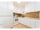 Clean kitchen featuring white cabinets, new appliances, and a stylish backsplash at 2391 Sumatran Way # 55, Clearwater, FL 33763