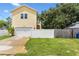 Front view of a yellow two story house with white fence at 2430 6Th N Ave, St Petersburg, FL 33713