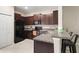 Modern kitchen with dark brown cabinets, granite countertops, and black appliances at 7203 Sweet Alyssum Ct, Tampa, FL 33619