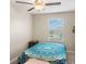 Cozy bedroom with ceiling fan, window blinds, and a patterned bedspread at 7203 Sweet Alyssum Ct, Tampa, FL 33619
