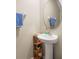 Small bathroom with pedestal sink, round mirror, and a neutral color palette at 7203 Sweet Alyssum Ct, Tampa, FL 33619