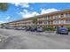 Exterior view of a condo building with ample parking at 6400 46Th N Ave # 117, Kenneth City, FL 33709