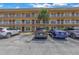 Exterior view of condo building with parking in front at 6400 46Th N Ave # 117, Kenneth City, FL 33709