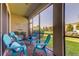 Relaxing screened porch with teal chairs and brick flooring at 2313 Sunset Wind Loop, Oldsmar, FL 34677