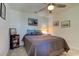 Bedroom with ceiling fan and gray bedding, offering additional storage at 2313 Sunset Wind Loop, Oldsmar, FL 34677
