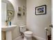 Updated half bathroom with pedestal sink, toilet, and decorative artwork at 2313 Sunset Wind Loop, Oldsmar, FL 34677