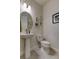 Clean half bathroom features a pedestal sink, toilet and framed art at 2313 Sunset Wind Loop, Oldsmar, FL 34677