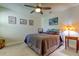 Bedroom with ceiling fan, gray bedding, and nightstand at 2313 Sunset Wind Loop, Oldsmar, FL 34677