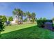 Green grassy backyard with palm trees and a partial view of the neighborhood at 2313 Sunset Wind Loop, Oldsmar, FL 34677