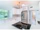 Modern white kitchen with stainless steel appliances and geometric backsplash at 161 Overbrook W St, Largo, FL 33770