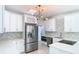 Modern white kitchen with stainless steel appliances and geometric backsplash at 161 Overbrook W St, Largo, FL 33770