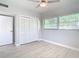 Bedroom with white louvered closet doors and ceiling fan at 161 Overbrook W St, Largo, FL 33770
