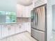 Modern white kitchen with stainless steel appliances and geometric backsplash at 161 Overbrook W St, Largo, FL 33770