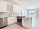 Modern white kitchen with stainless steel appliances and geometric backsplash at 161 Overbrook W St, Largo, FL 33770