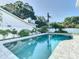 Refreshing turquoise pool, bordered by a gray stone patio at 161 Overbrook W St, Largo, FL 33770