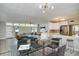 Open concept dining room with glass table and chairs, adjacent to living room and kitchen at 161 Overbrook W St, Largo, FL 33770