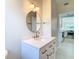 Updated bathroom with white vanity, round mirror, and gold accents at 161 Overbrook W St, Largo, FL 33770