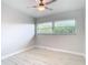 Bright bedroom with ceiling fan, window blinds, and light wood flooring at 161 Overbrook W St, Largo, FL 33770