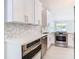 White cabinets, geometric backsplash, stainless steel appliances in this kitchen at 161 Overbrook W St, Largo, FL 33770