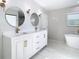 Elegant bathroom with double vanity, large mirrors, and herringbone tile at 161 Overbrook W St, Largo, FL 33770