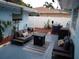 Cozy back patio with outdoor seating, fire pit table, grill, string lights, and white vinyl privacy fence at 5 158Th Ave, Redington Beach, FL 33708