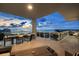 A covered balcony with tile floors offers sweeping water views and outdoor dining space at sunset at 540 N Tamiami Trl # 1702, Sarasota, FL 34236
