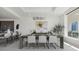 A modern dining room with gray walls, recessed lights, and view into the kitchen at 540 N Tamiami Trl # 1702, Sarasota, FL 34236