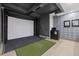 Indoor golf simulator with a projector screen, turf, and modern design for year-round practice at 540 N Tamiami Trl # 1702, Sarasota, FL 34236