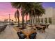 Chic rooftop lounge with tables and chairs near palm trees, ideal for outdoor relaxation and gatherings at 540 N Tamiami Trl # 1702, Sarasota, FL 34236