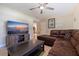 Living room with L-shaped sectional sofa, large TV, and kitchen view at 5733 66Th N Ln, St Petersburg, FL 33709