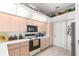 View of kitchen with wood cabinets, appliances, and a pantry at 5199 Panther Dr, Spring Hill, FL 34607