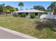 Single-story home with a spacious front lawn and palm trees at 7979 Garden N Dr, St Petersburg, FL 33710