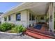 Covered front porch with terracotta tile flooring and ornate railings at 7979 Garden N Dr, St Petersburg, FL 33710