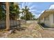 Large backyard with dirt ground, wooden fence, and stone bench at 7979 Garden N Dr, St Petersburg, FL 33710