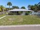 Single story home with a large front lawn and mature landscaping at 7979 Garden N Dr, St Petersburg, FL 33710