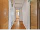 Long hallway with light wood floors and access to other rooms at 7979 Garden N Dr, St Petersburg, FL 33710
