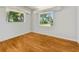 Empty bedroom with hardwood floors and two windows at 7979 Garden N Dr, St Petersburg, FL 33710