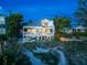 Back exterior of beach house at dusk with lights on at 20052 Gulf Blvd, Indian Shores, FL 33785