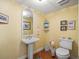 Small bathroom with pedestal sink, toilet and hardwood floor at 20052 Gulf Blvd, Indian Shores, FL 33785