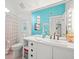 Bathroom with white vanity, glass block shower, and teal walls at 20052 Gulf Blvd, Indian Shores, FL 33785