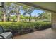 Brick patio with seating area, lush landscaping, and view of trees and parking lot at 36750 Us Highway 19 # 23-110, Palm Harbor, FL 34684